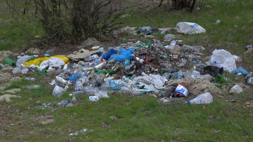 Plastic debris on the river bank. Pollution of nature | Shutterstock HD Video #1097294311