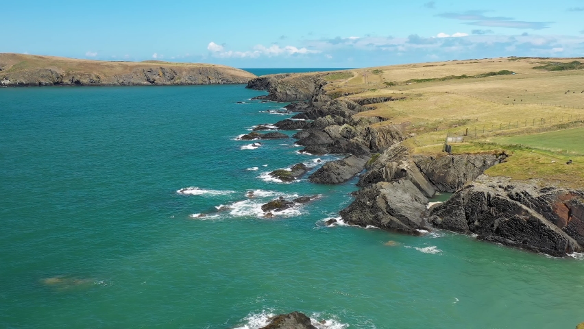 Aerial view of the Welsh coastline in summer (Gwbert, Pembrokeshire, Wales) | Shutterstock HD Video #1097295047