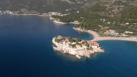 Aerial video of the famous tourist location Sveti Stefan island and picturesque Adriatic coastline near the city of Budva, Montenegro.