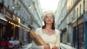 Portrait of a beautiful woman with baguettes looking at the camera on the street