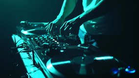 Techno party DJ mixing music with sound mixer and turntables. Hip hop disc jockey plays set on party in night club