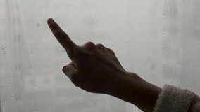 Ukraine. Apartment without heating and electricity. A child writes the word peace on fogged glass. - Powered by Shutterstock - Get 15% off with code: PIKWIZARD15