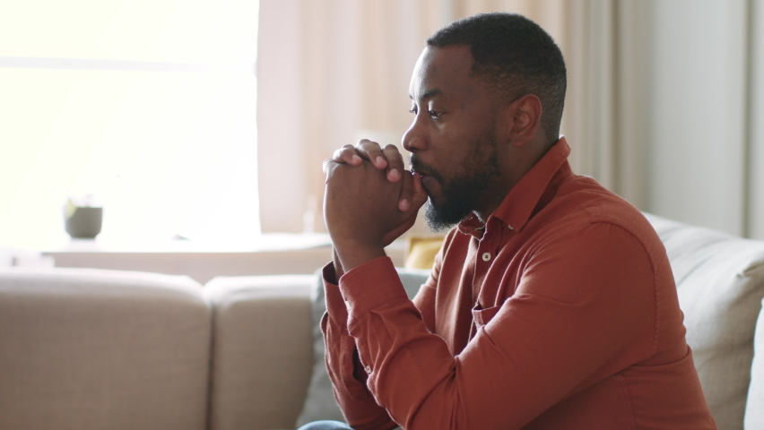 Personal crisis. Desperate african american man suffering from problems, thinking over solutions at home, sitting on sofa alone, tracking shot, slow motion, empty space Royalty-Free Stock Footage #1097300703