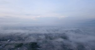 Drone shot above urban areas shrouded in sea of mist