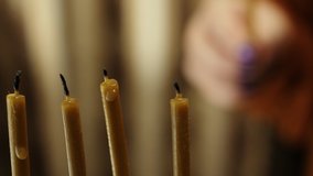 A woman's hand lights candles on the last day of Hanukkah from a shamash candle in a Hanukkah candlestick - Powered by Shutterstock - Get 15% off with code: PIKWIZARD15