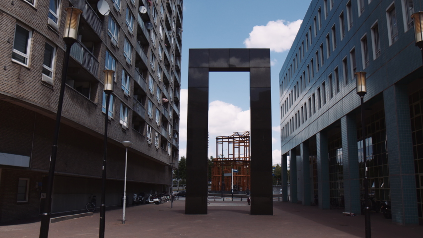 Slowmotion shot of a marble archway with the Nieuwe Delftse Poort sculpture in the background, Rotterdam, Netherlands