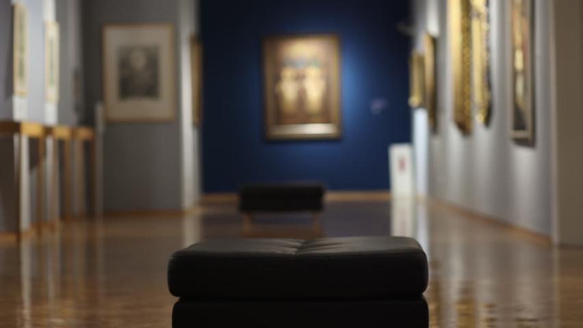 Education and culture. Tired young Caucasian woman with glasses sits down on sofa and sighs boringly. Concept of visiting art gallery and museum
