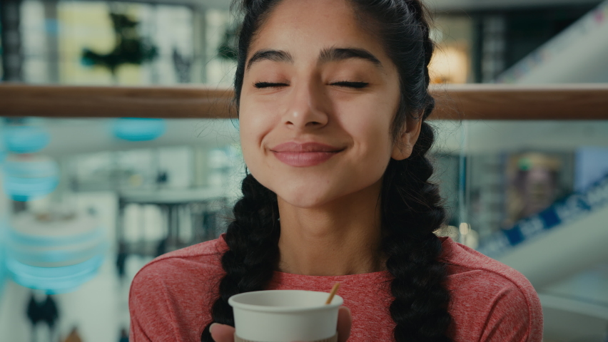 Portrait gorgeous arabian joyful girl student woman visitor sitting at cafe smelling aroma coffee cappuccino espresso or herbal tea smiling woman enjoy tasty beverage hot drink feel comfort relaxing