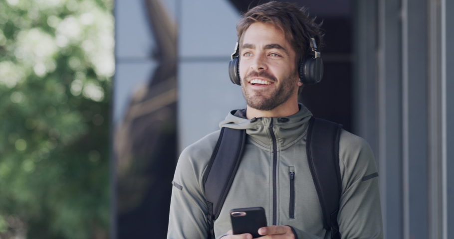 Travel, phone and man walking in city with headphones enjoying freedom, holiday and weekend. Technology, mobile app and young male typing on smartphone and listening to music in street of urban town | Shutterstock HD Video #1097324891