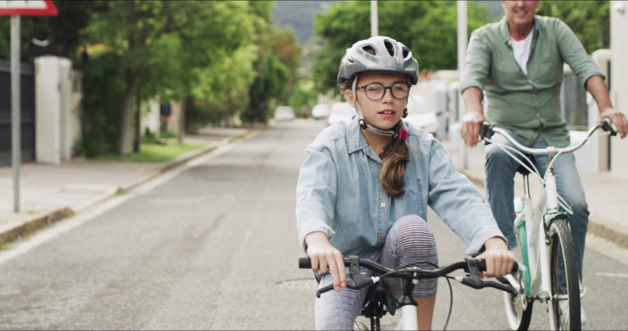 Cycling, bonding and girl on a bike with grandfather, content and quality time in the neighborhood street. Family, adventure and child with a senior man on a bicycle in the road for happiness | Shutterstock HD Video #1097324913