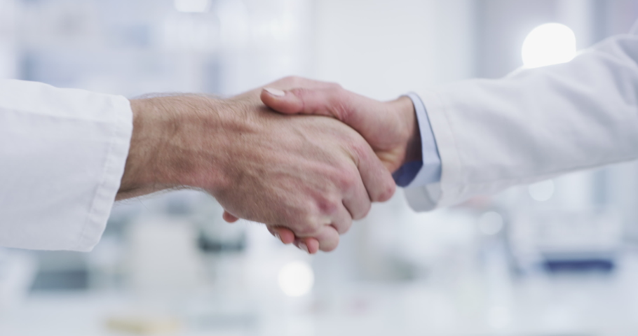 Doctor, handshake and science for b2b, partnership or agreement in teamwork trust at the hospital. Healthcare professionals shaking hands for introduction, welcome or meeting in medical clinic or lab Royalty-Free Stock Footage #1097325001