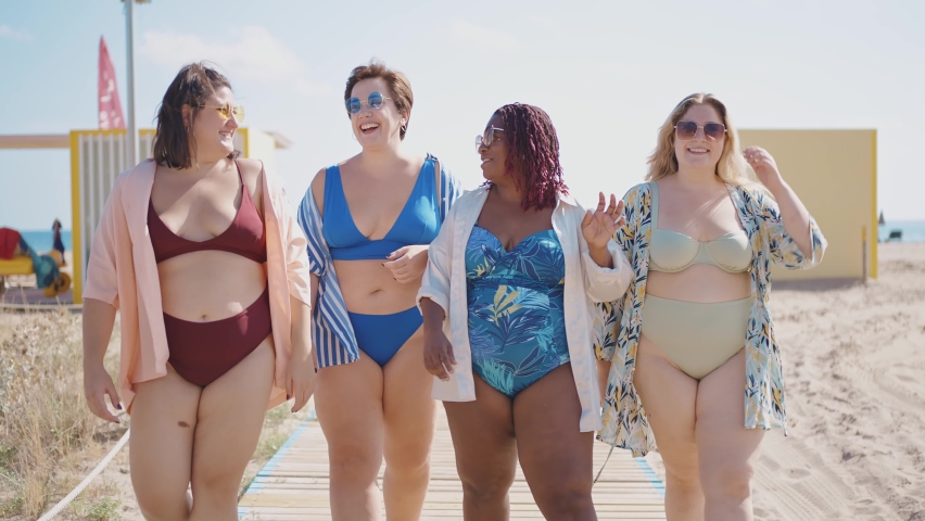 Cinematic storytelling footage of beautiful plus size women having fun at the beach in the summertime. Oversized big girls friends, representation of body positivity and body acceptance concepts Royalty-Free Stock Footage #1097325209