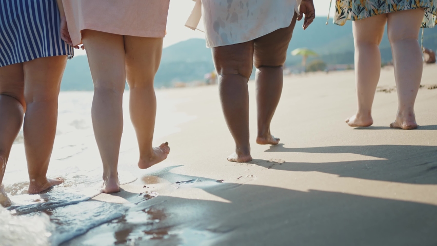 Cinematic storytelling footage of beautiful plus size women having fun at the beach in the summertime. Oversized big girls friends, representation of body positivity and body acceptance concepts Royalty-Free Stock Footage #1097325239