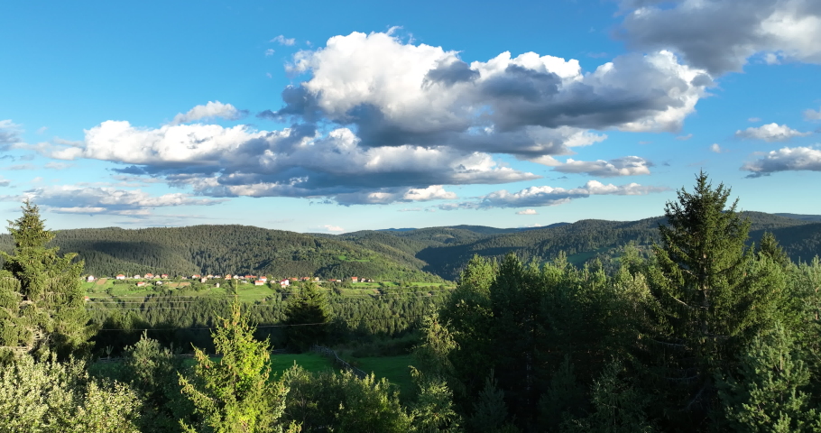 panorama of beautiful countryside of romania. sunny afternoon. wonderful springtime landscape in mountains. grassy field and rolling hills. rural scenery