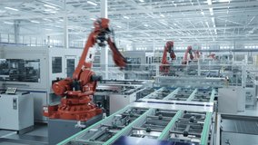 Time-lapse video of Automated Solar Panel Production Line. Orange Industrial Robot Arm Assembles Solar Panel, Placing PV Cells. Modern, Bright Manufacturing Facility.