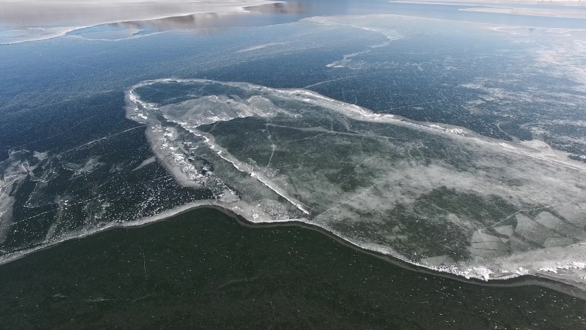Aerial view of frozen water surface in polar region of northern hemisphere. Royalty-Free Stock Footage #1097327099