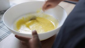Children's hands knead the dough for making a cake.