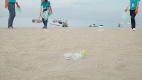 Volunteers collect trash in a trash bag.Greening the planet,Plastic pollution and environmental problem concept.Voluntary cleaning of nature from plastic.Teamwork cleaning plastic on the beach. - Powered by Shutterstock - Get 15% off with code: PIKWIZARD15