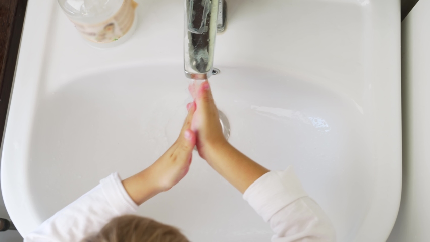 Top view. washing children's hands with soap in the sink. the concept of hygiene in kindergartens and schools. mandatory hand washing before eating and after a walk. | Shutterstock HD Video #1097328863
