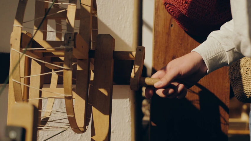 Hands spinning thread on spinning wheel. Hands combing cotton. Yarn technology. 4k | Shutterstock HD Video #1097334423