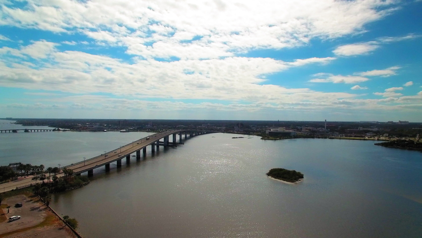 Aerial Backward Shot Of Cars Moving On Bridges Over Sea In City Under Cloudy Sky - Daytona Beach, Florida
