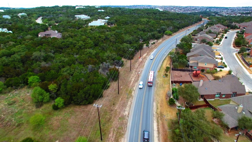 Aerial Shot Of Coach Bus And Cars Moving By Roofed Houses In City, Drone Flying Forward Over Road - San Antonio, Texas
