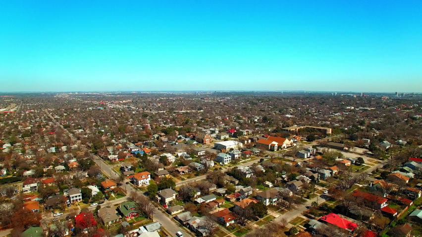 Aerial Panning Shot Of Roofed Houses On City Horizon Against Clear Sky - San Antonio, Texas