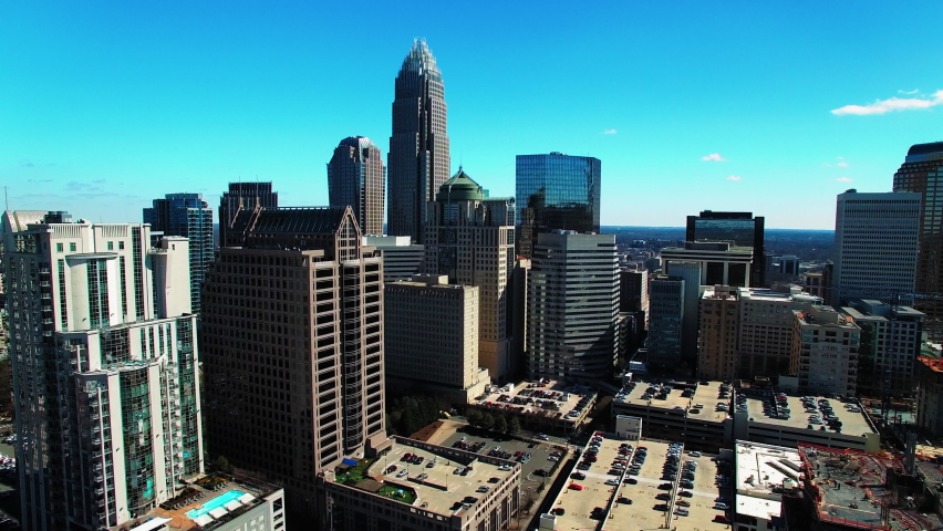 Aerial Forward Shot Of Cars Parked By Modern Building, Drone Moving Over Skyscrapers During Sunny Day - Charlotte, North Carolina