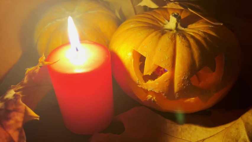 Halloween and holidays. Pumpkin lantern or carved pumpkin and red candle in the dark. | Shutterstock HD Video #1097339189
