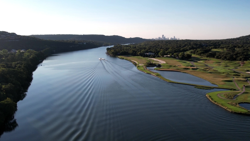 Aerial drone backward moving shot flying above the Pennybacker Bridge in Austin, Texas along hillside at daytime.