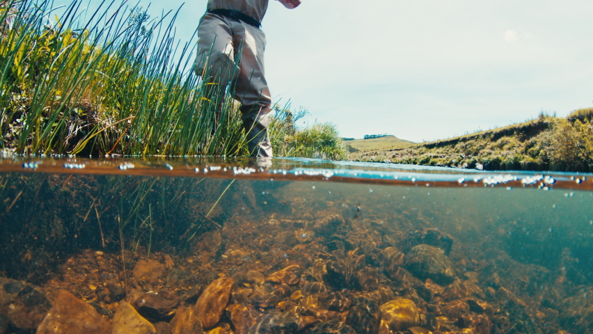 Fisherman underwater view. Angler walks in the wading boots on the slippery rocky bottom of a rapid river Royalty-Free Stock Footage #1097350635