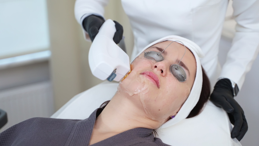 Woman undergoing cosmetic procedures being provided by means of bbl laser. Facial treatment, improving skin condition at cosmetology clinic | Shutterstock HD Video #1097356069