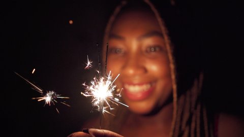 Sparking cold fires held by an African woman on New Year's Eve. - Βίντεο στοκ