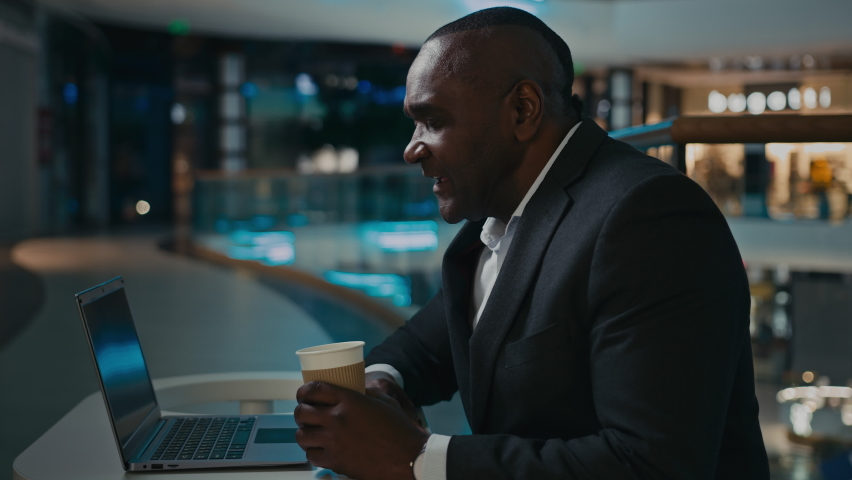 African middle-aged adult businessman worker entrepreneur man boss leader specialist company CEO talking video call online conference with laptop corporate meeting in cafe with coffee cup talk chat | Shutterstock HD Video #1097360721