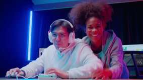 Young asian man and African American woman wearing headset play video game and live streaming online with microphone together, gaming and esport or casting game with excited, entertainment concept.