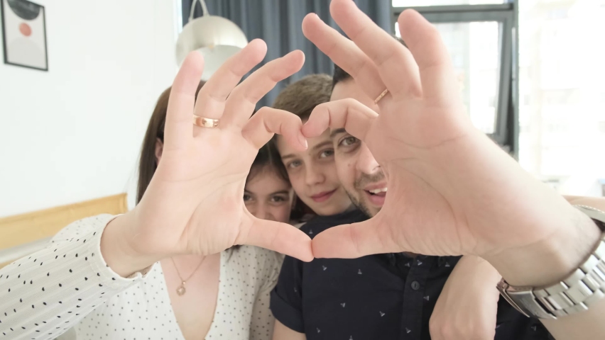 A big family is the heart. Dad, mom and daughter make a heart-shaped hand gesture.  Royalty-Free Stock Footage #1097361369