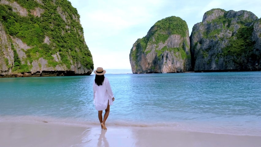 Women with a hat walking on the beach at Koh Phi Phi Thailand at Maya Bay the famous beach in Thailand | Shutterstock HD Video #1097364599