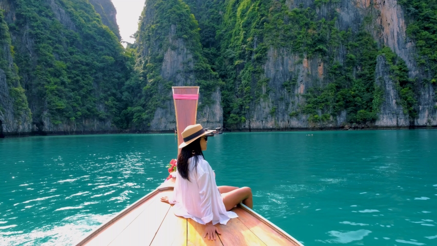 Pileh Lagoon with the green emerald ocean at Koh Phi Phi Thailand, women in front of a longtail boat | Shutterstock HD Video #1097364623