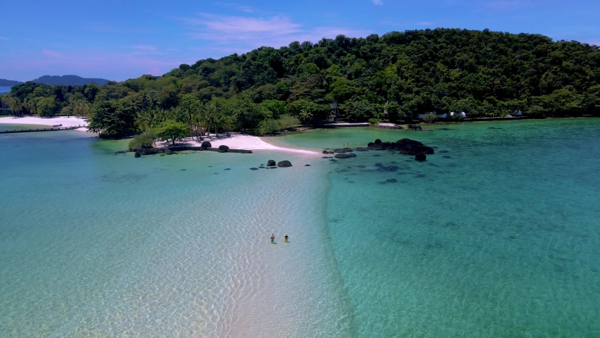 Drone aerial view at a Couple man and women on a tropical island in Thailand, Koh Kham Island Trat Koh Mak. tropical beach with white sand and blue ocean with palm trees | Shutterstock HD Video #1097364631