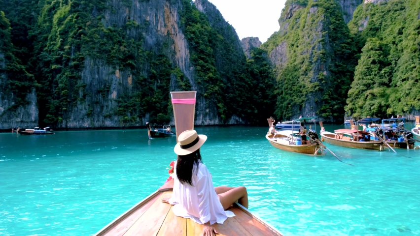 Pileh Lagoon with the green emerald ocean at Koh Phi Phi Thailand, women with hat in front of longtail boat | Shutterstock HD Video #1097364651