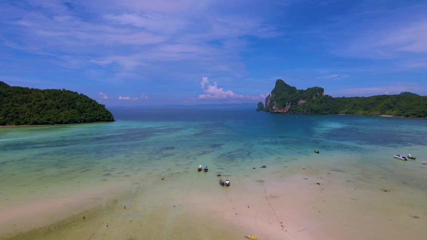 Koh Ph Phi Don Thailand, turqouse color ocean with kayaks and longtail boats at the beach in the morning sun. Loh Dalum Beach  | Shutterstock HD Video #1097364657