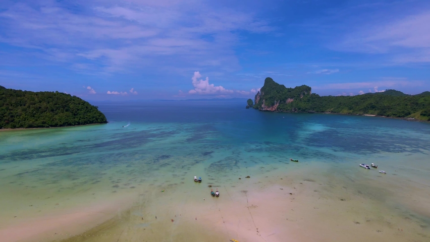 Koh Ph Phi Don Thailand, turqouse color ocean with kayaks and longtail boats at the beach in the morning sun. Loh Dalum Beach  | Shutterstock HD Video #1097364673