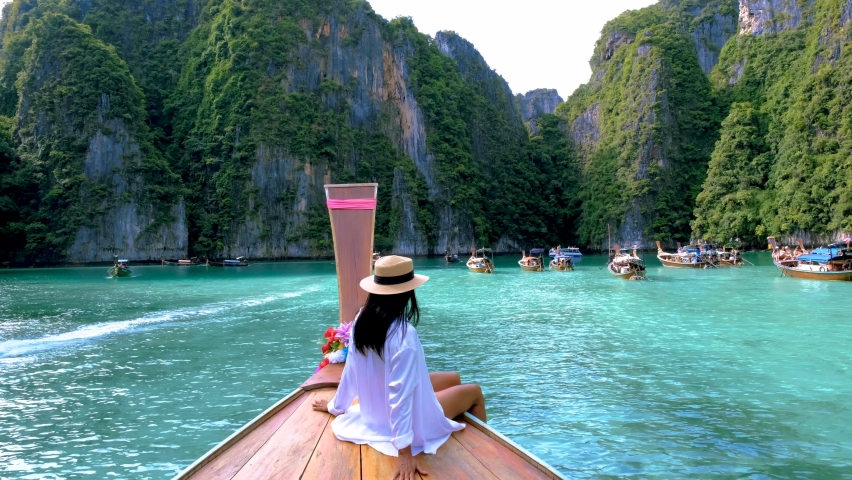 Pileh Lagoon with the green emerald ocean at Koh Phi Phi Thailand, Thai Asian women in front of longtail boat | Shutterstock HD Video #1097364691