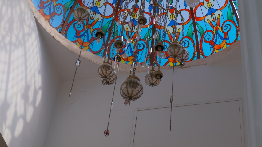Top of stained glass church window. A view of stained glass dome in the white church. A concept of religion traveling place.