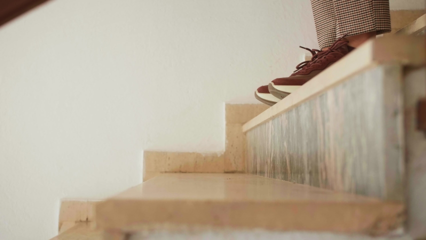 Woman in casual clothes goes down stairs. Close up of legs stepping down stairs. Royalty-Free Stock Footage #1097374589