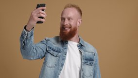 Caucasian, red-haired man streaming video for his followers. Close-up shot of male blogger during a video call. High quality 4k footage