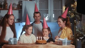 kid birthday. little girl blows out the candles on the cake in a circle of happy family. celebration dream birthday kid concept. friendly happy family celebrating birthday a lot of people - Powered by Shutterstock - Get 15% off with code: PIKWIZARD15
