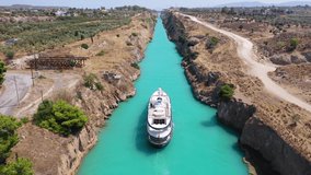 Aerial drone video of yacht crossing famous narrow Corinthian gulf canal known as Isthmus from Saronic gulf to Corinthian gulf avoiding making full tour of Peloponnese, Greece
