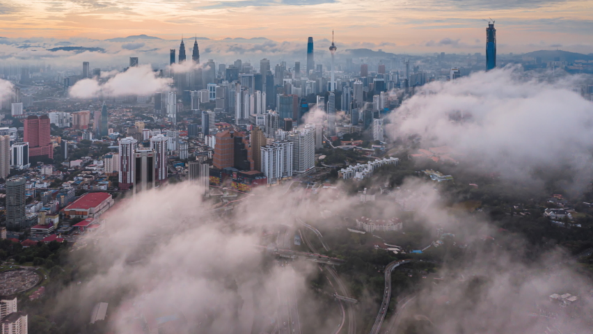 Cityscape Time lapse : Wide angle aerial Kuala Lumpur city view with nice low clouds during sunrise overlooking the KL city skyline in Malaysia. Tilt up motion time lapse. Prores 4KUHD Royalty-Free Stock Footage #1097382857