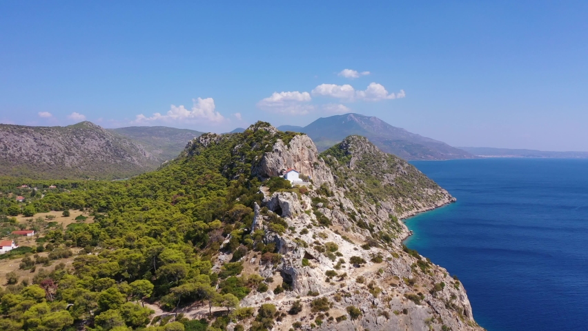 Aerial drone video of small uphill church of Agios Nikolaos overlooking archaeological site of Heraion in Cape Melagavi, Corinthian bay, Perachora, Loutraki, Greece